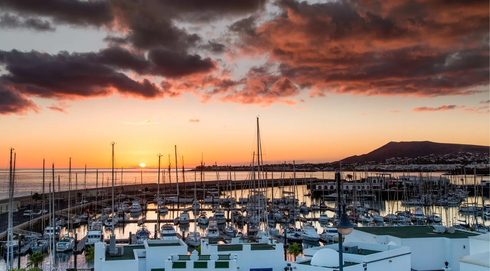 Sunset over the yacht-filled harbour at Playa Blanca, Lanzarote, with orange and purple cloud
