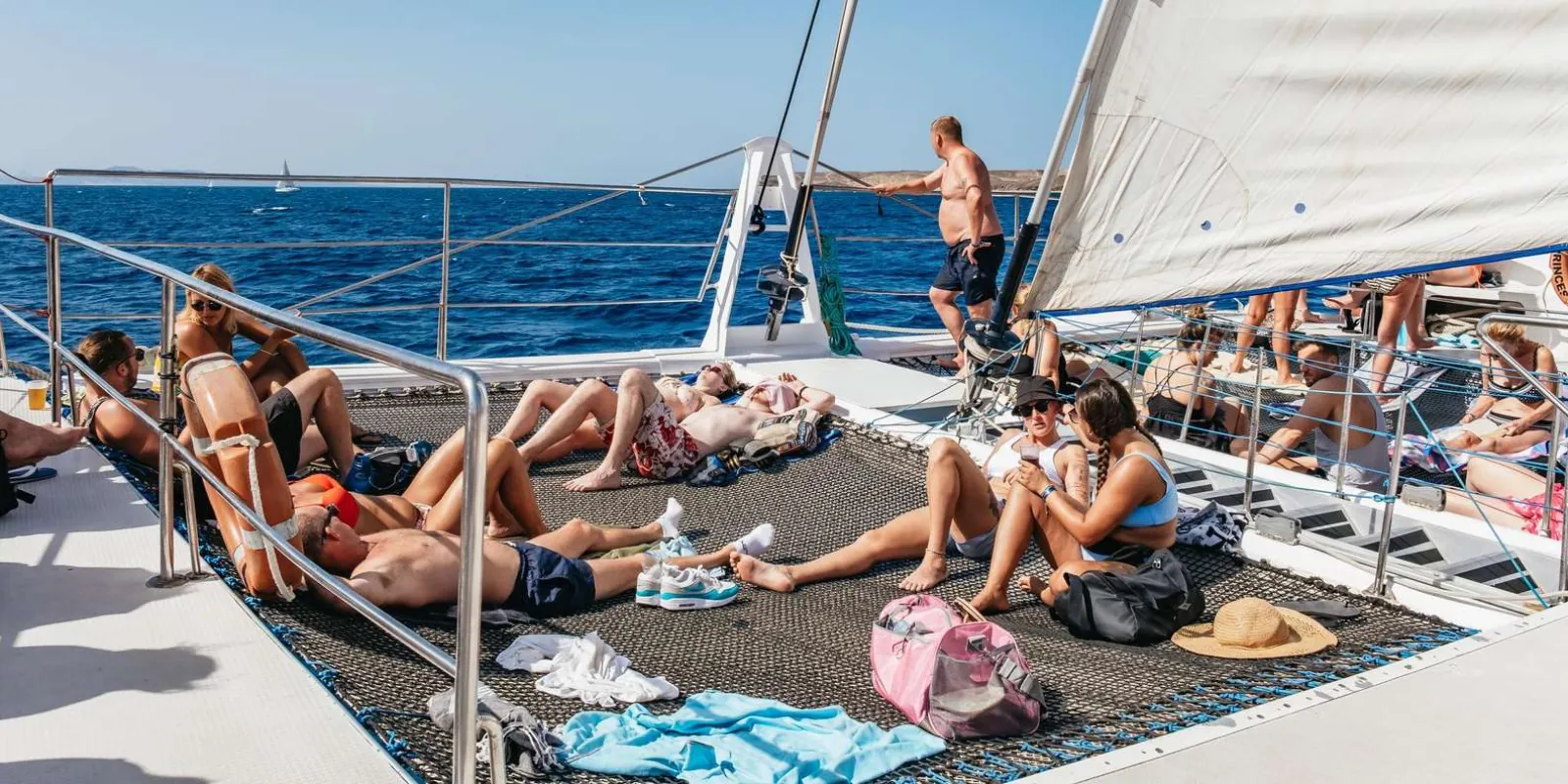 Passengers sunbathing on the trampoline nets and foredeck of the Papagayo catamaran