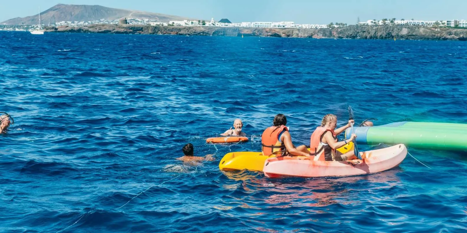 Guests kayaking and swimming in turquoise water off the Papagayo coast