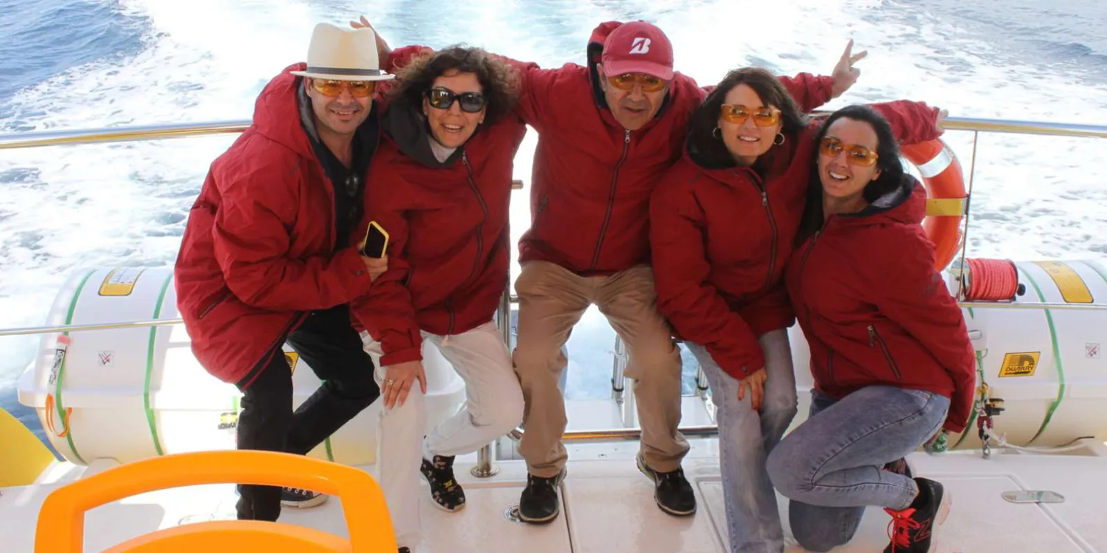 A group of guests in red jackets on the deck of the Lobos Island boat