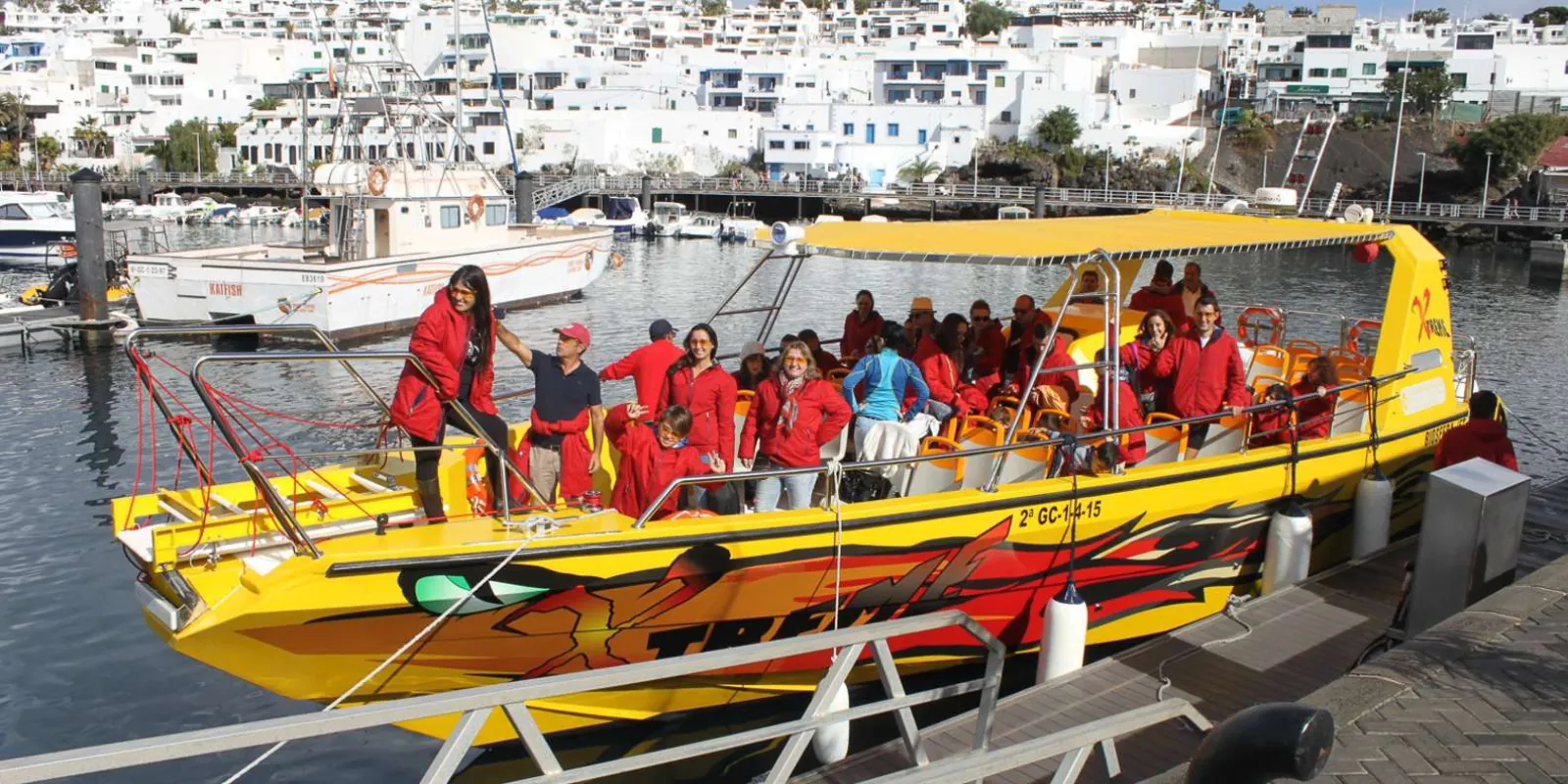 The yellow and red fast boat boarding passengers at the Puerto del Carmen quayside
